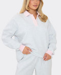 Light blue women's soft sweatshirt with pale pink collar and ribbed cuffs