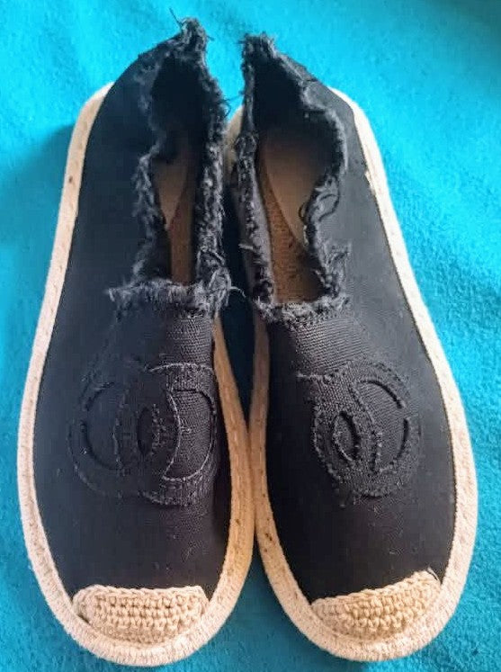 Women’s black espadrilles with woven jute soles and textured logo-like side panels