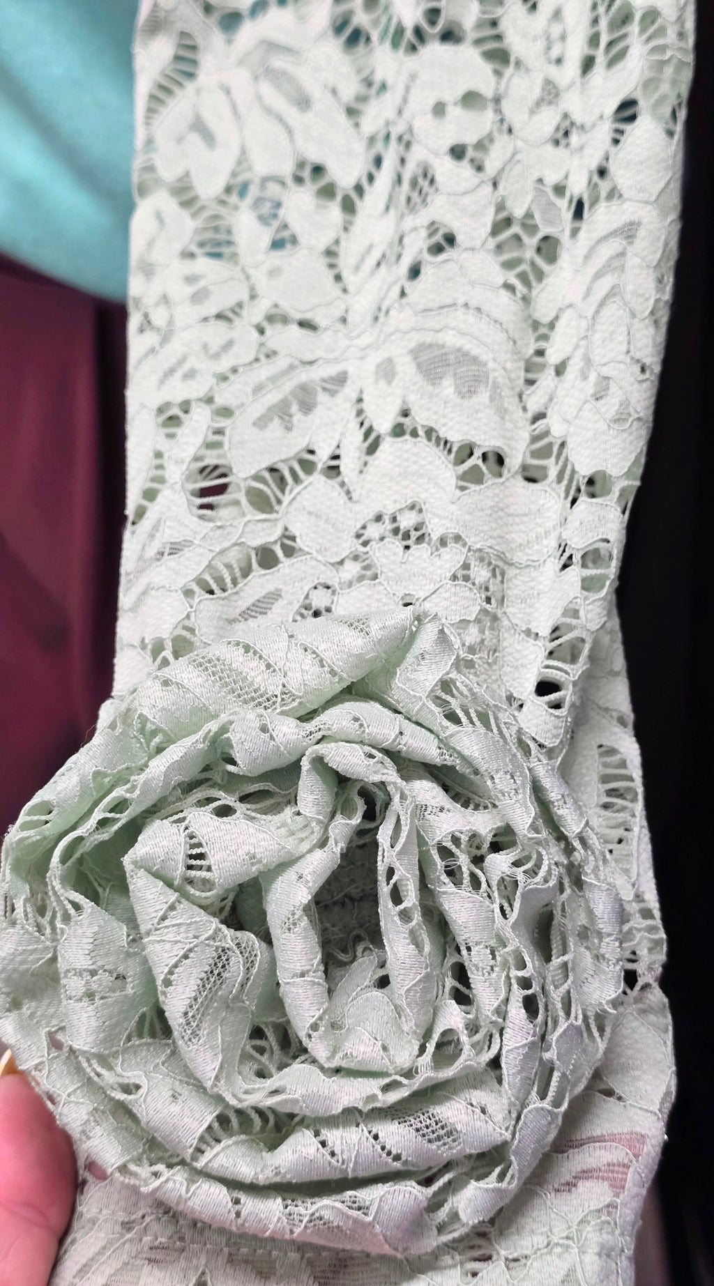 White lace rose applique with ruffled texture on blouse sleeve
