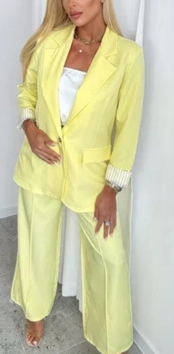Women's yellow suit with blazer and wide-leg trousers, striped cuffs visible
