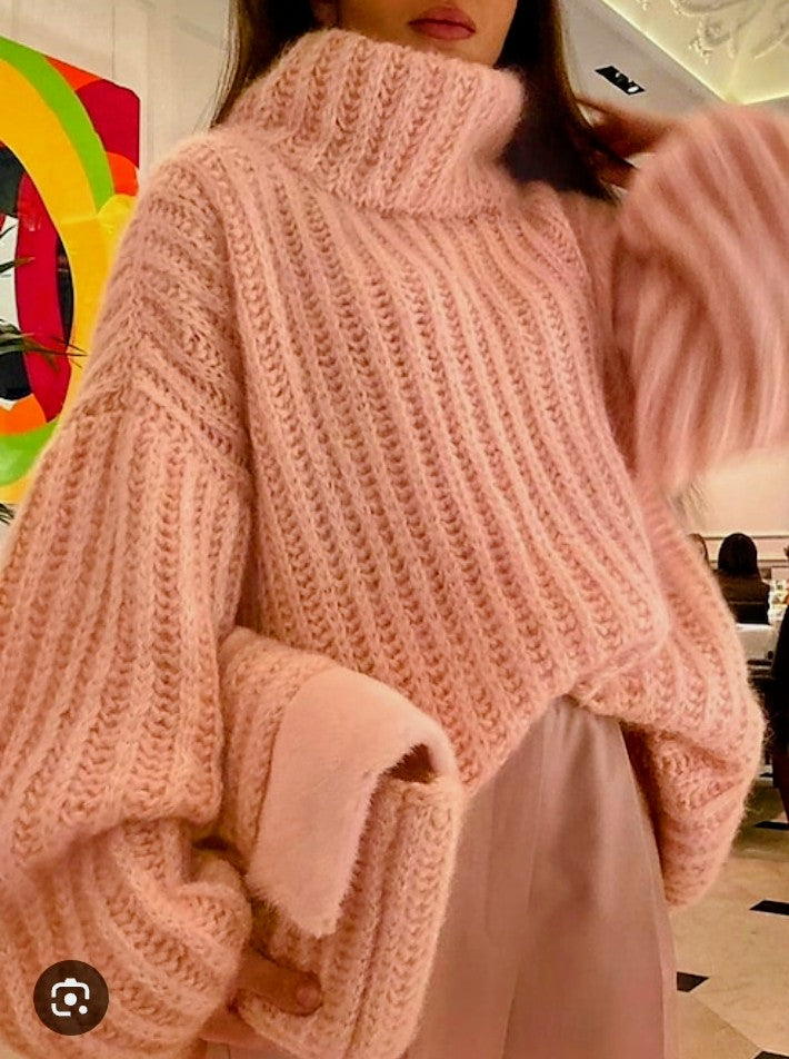 Light pink cable-knit turtleneck top with long sleeves and ribbed cuffs.