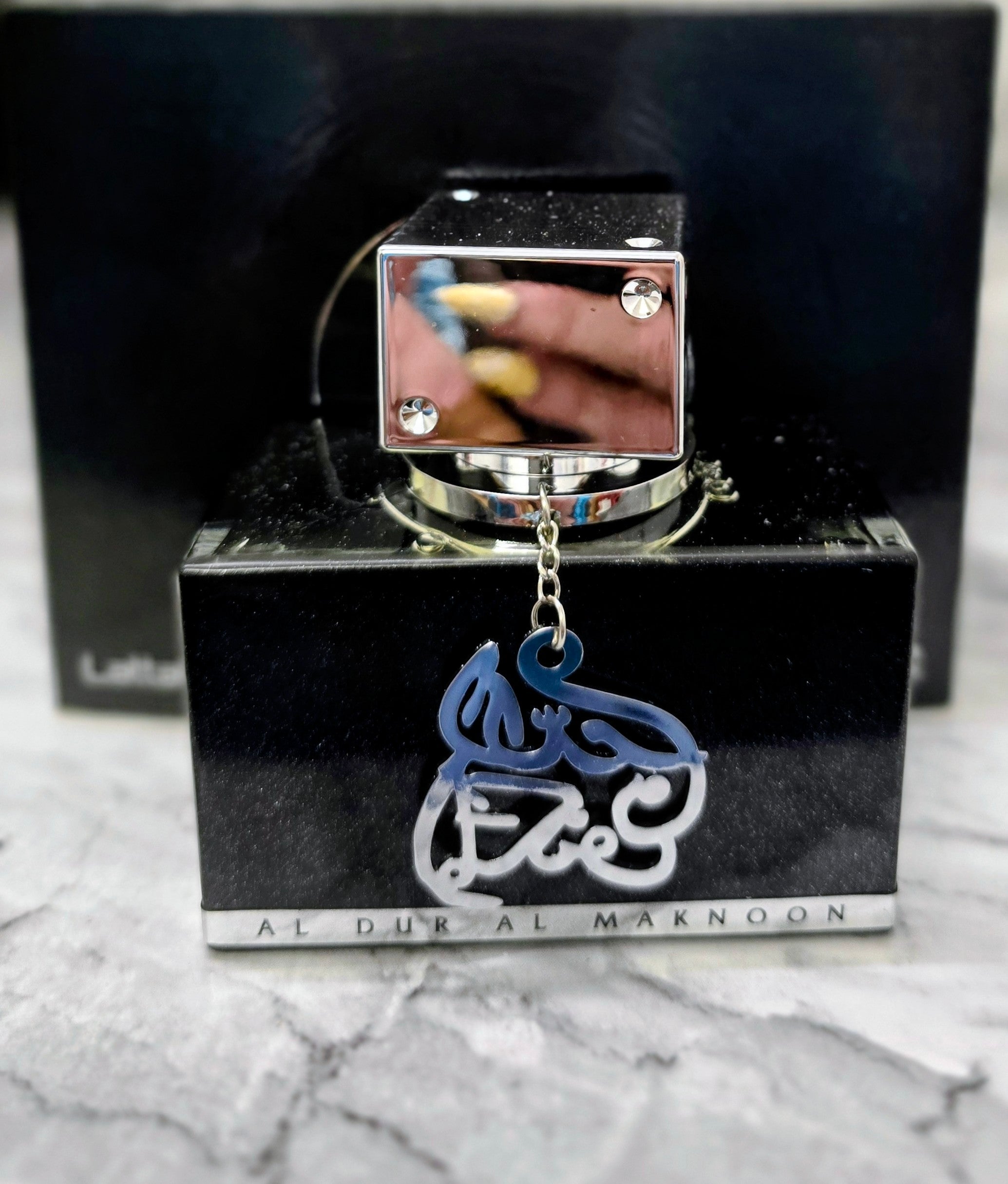 Men's eau de parfum box by Lattafa, dark with blue logo charm and metal cap