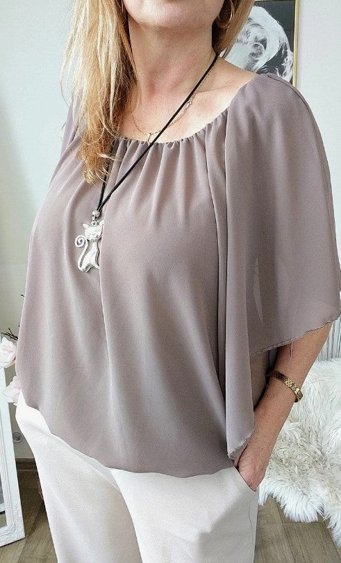 An elegant women's blouse with a pendant.