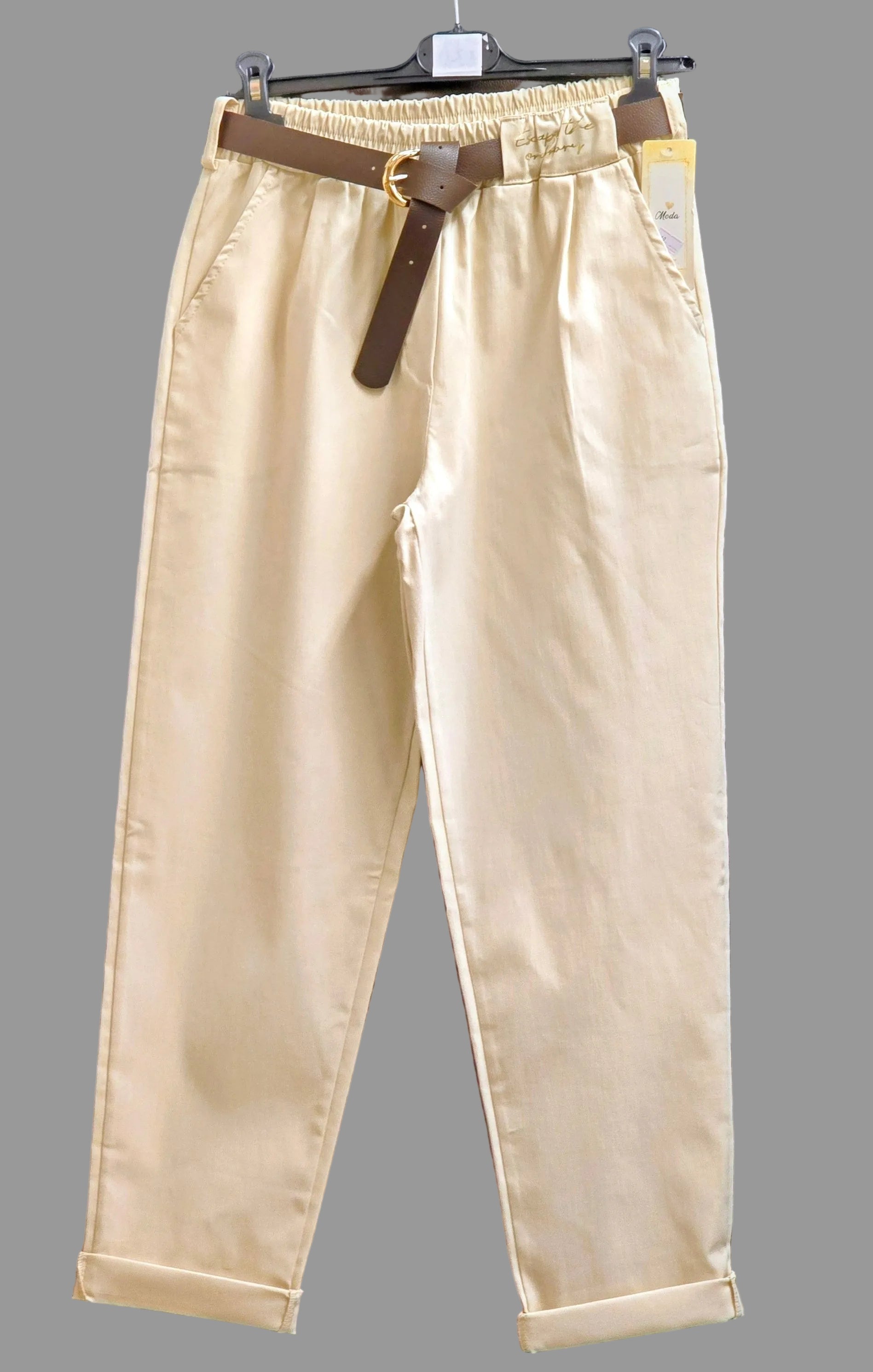 Beige women’s punto trousers with dark belt, cuffed hems and front pleats.