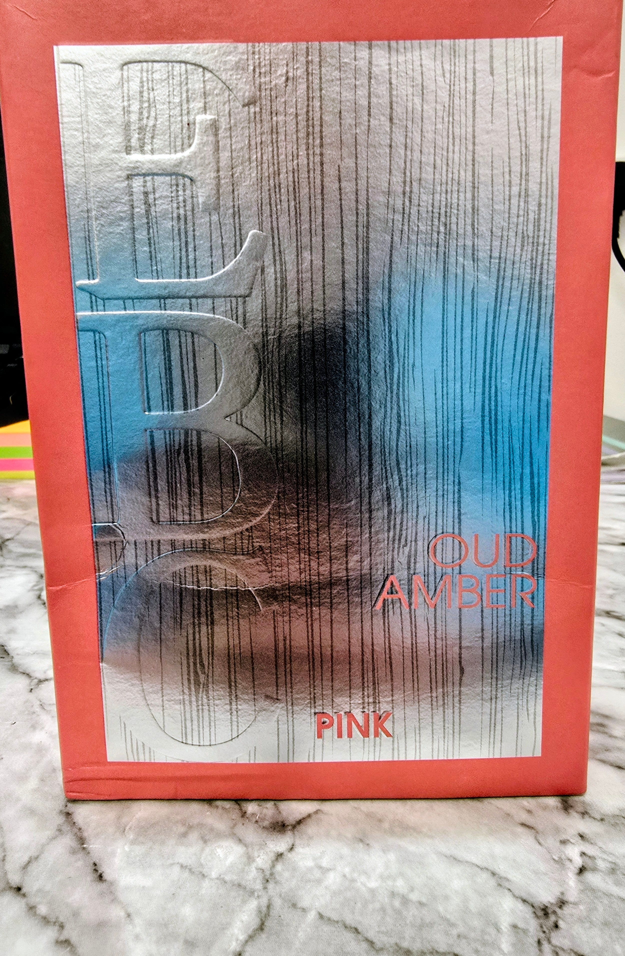 Perfume gift box with embossed letters, Cloud Amber and Pink text.