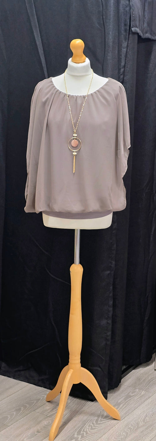 An elegant women's blouse with a pendant.